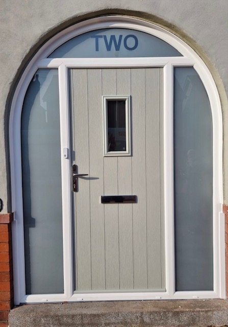 Composite front door with arch frame in pale grey
