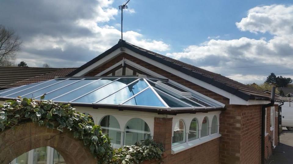 Photo of an orangery with a glass roof on a sunny day