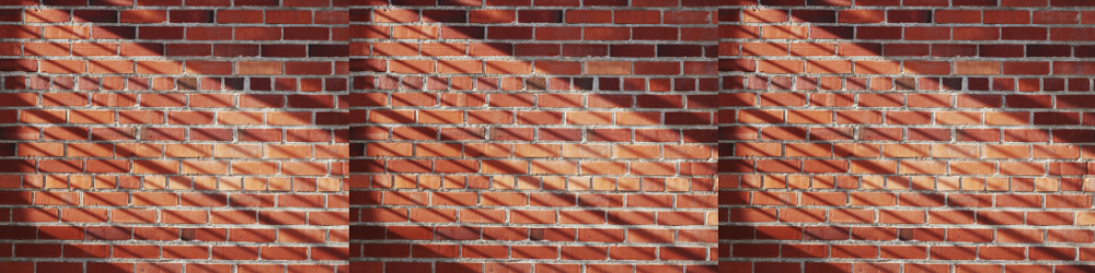 a photograph of a red brick wall with sunlight streaming across it
