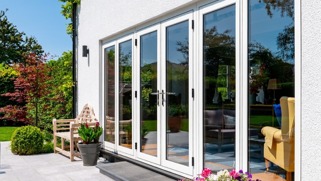a photograph of the exterior house, showing a neatly kept garden and white upvc patio doors