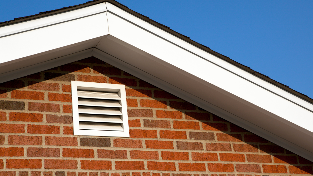 a photograph of a red brick house with a white ventilation cover